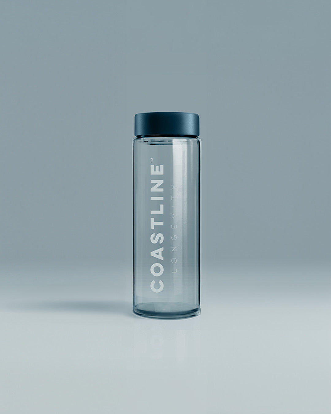 A clear glass shaker bottle with 'COASTLINE' written on it, featuring a black lid, placed against a neutral background.