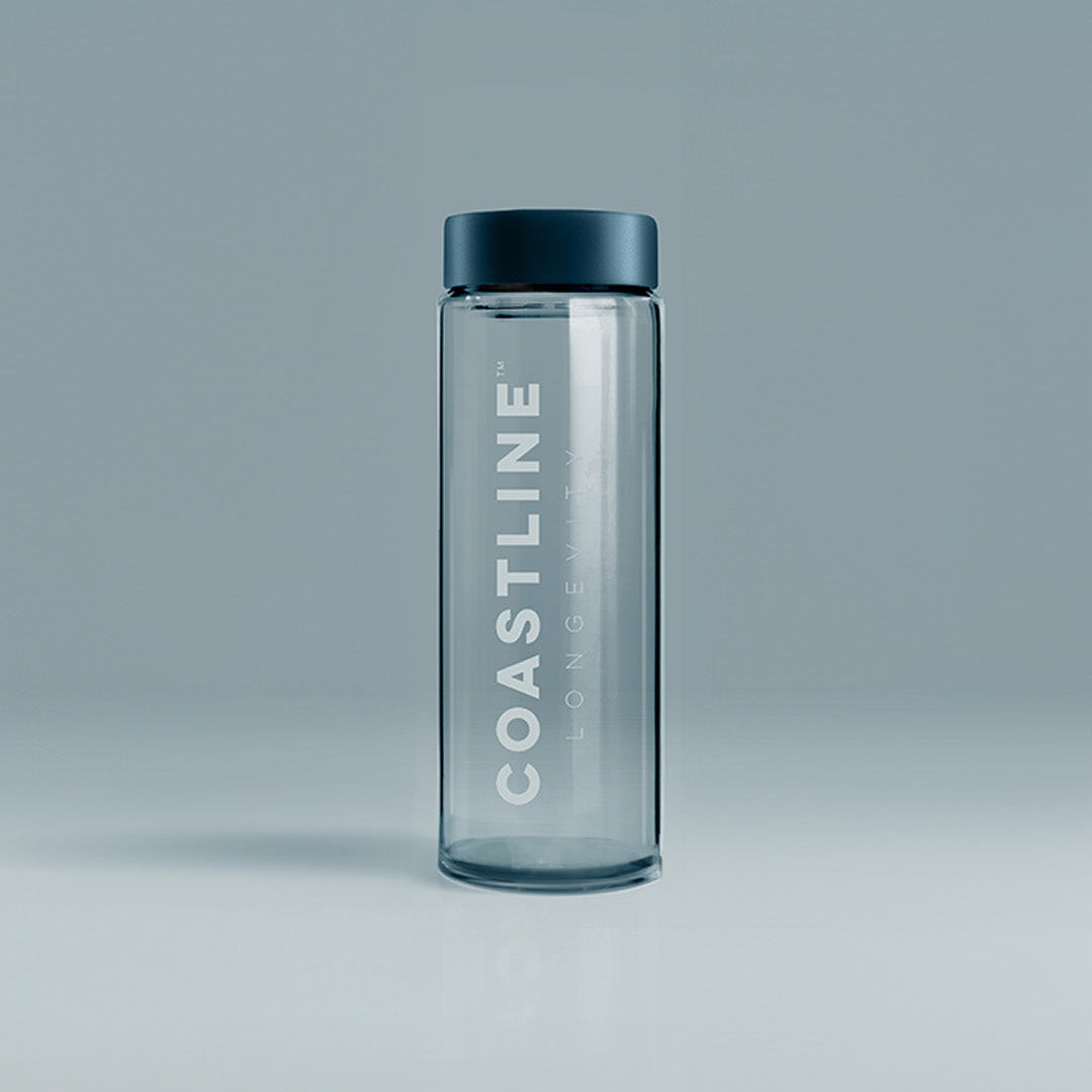 A clear glass shaker bottle with 'COASTLINE' written on it, featuring a black lid, placed against a neutral background.